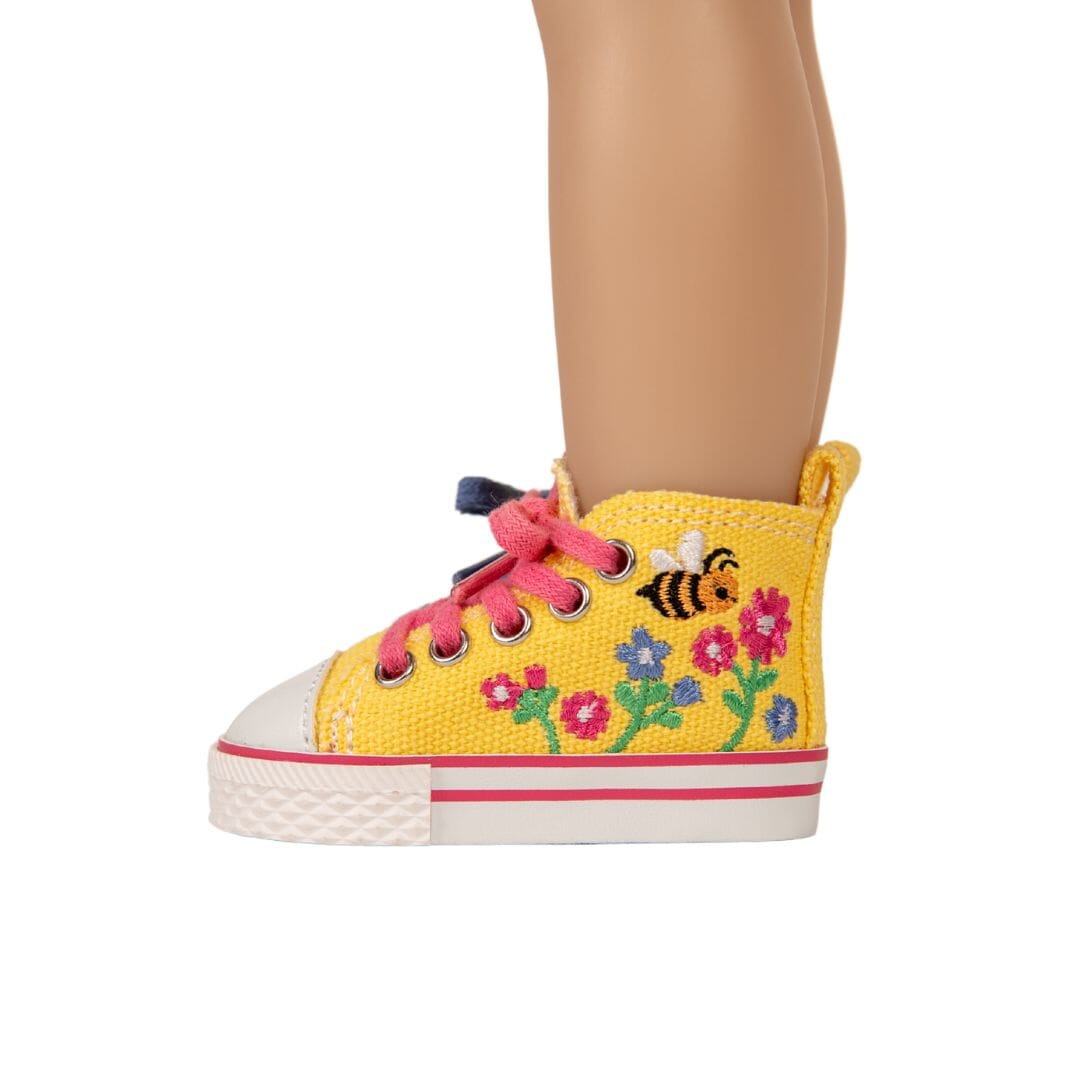 Bright yellow high top runners for dolls are embroidered with colourful flowers and buzzing bee