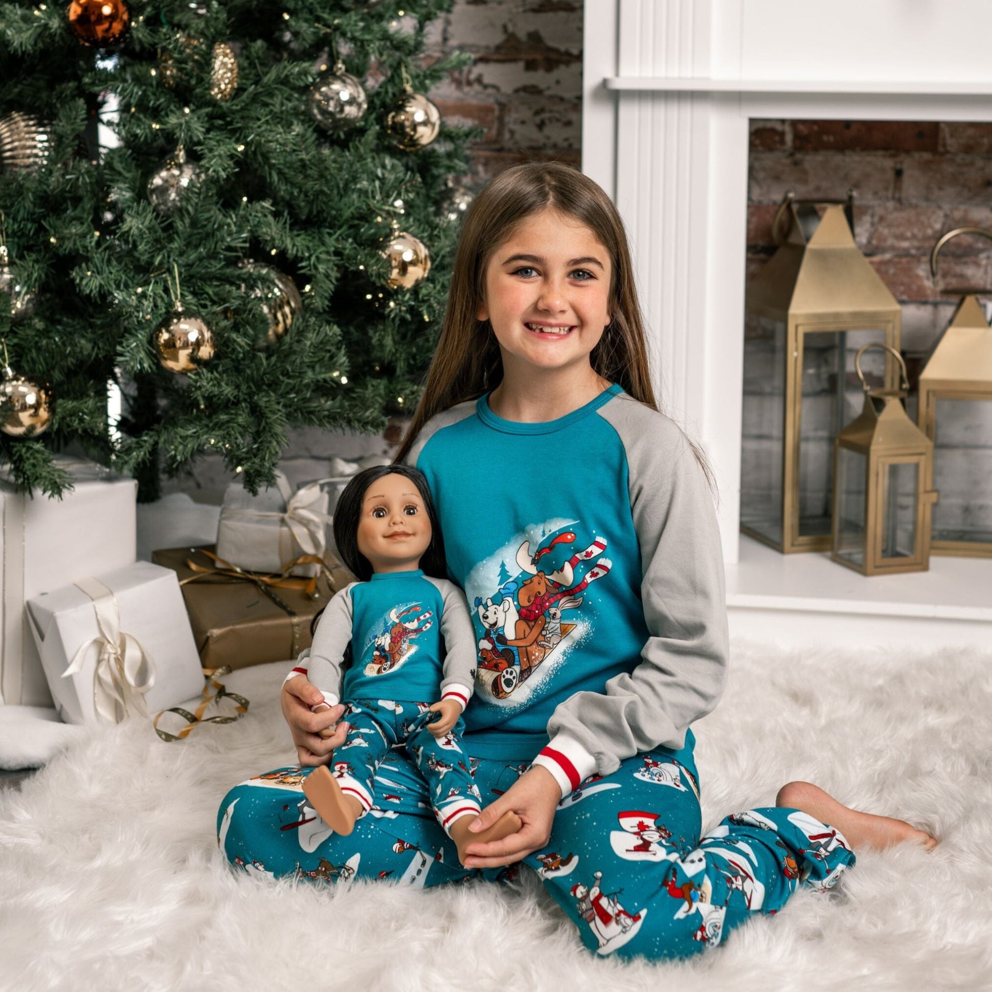 girl and her girl doll wearing matching slippery slope pjs