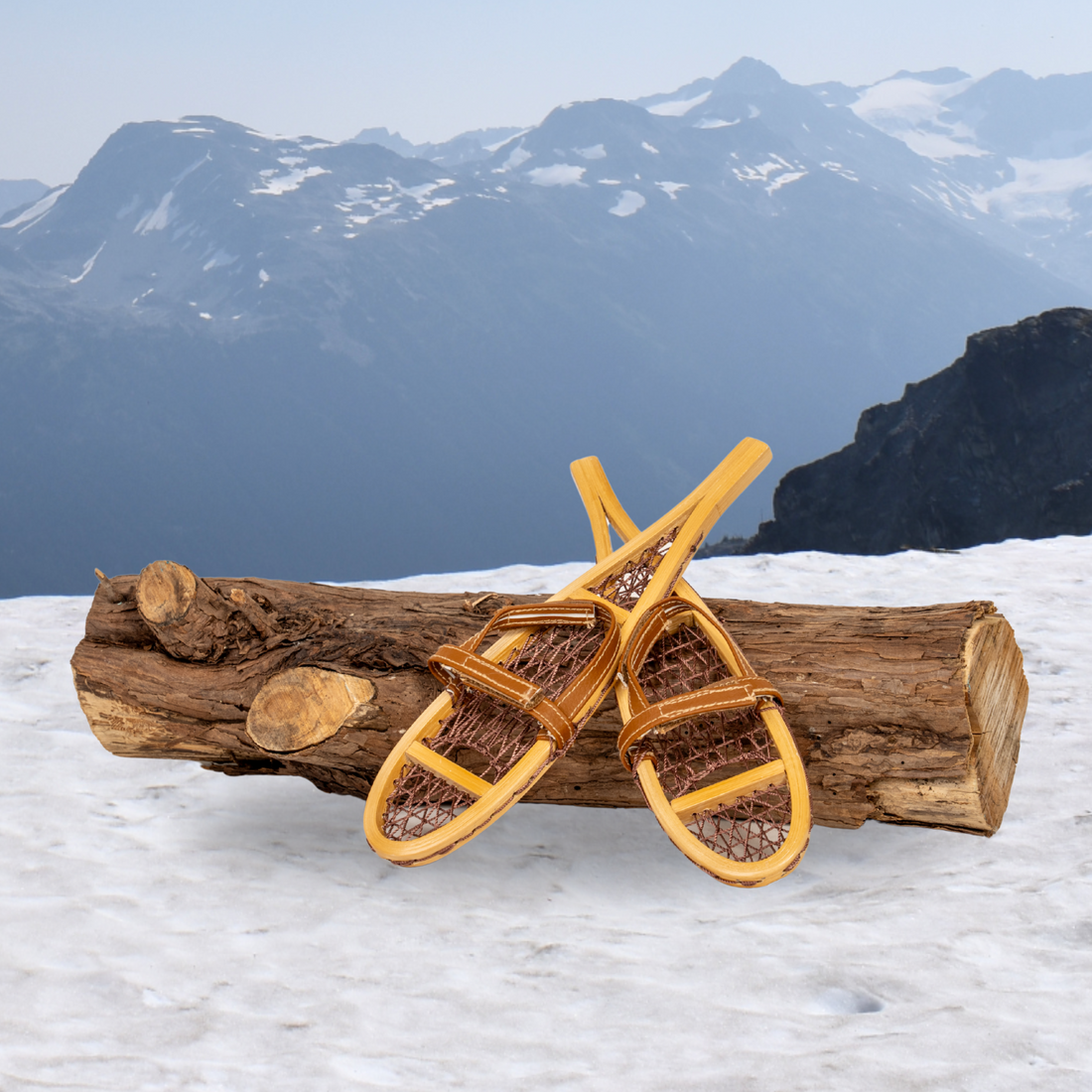 Two wooden snowshoes for 18-inch dolls on a log.