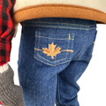 18-inch doll blue jeans with a maple leaf embroidered design on the pocket.