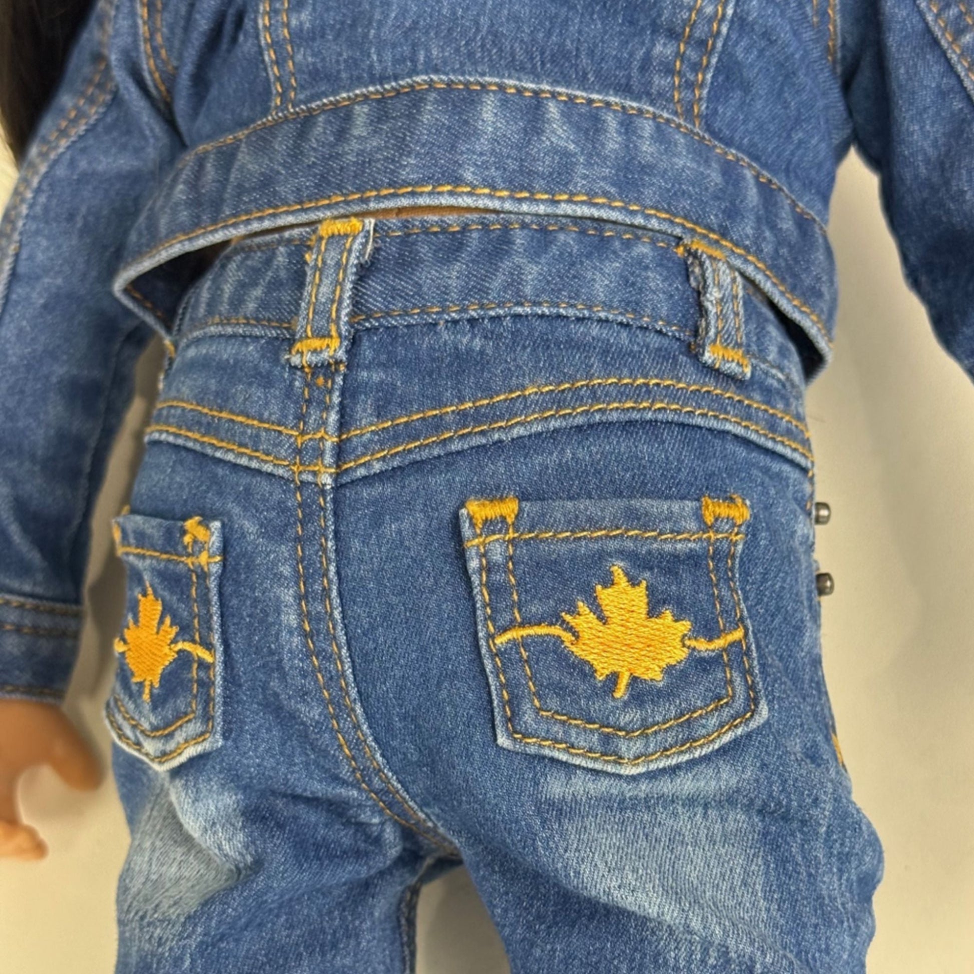 Close-up of blue jeans with gold stitching for 18-inch dolls.
