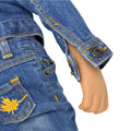 Close-up of a doll wearing blue jeans with a maple leaf design.