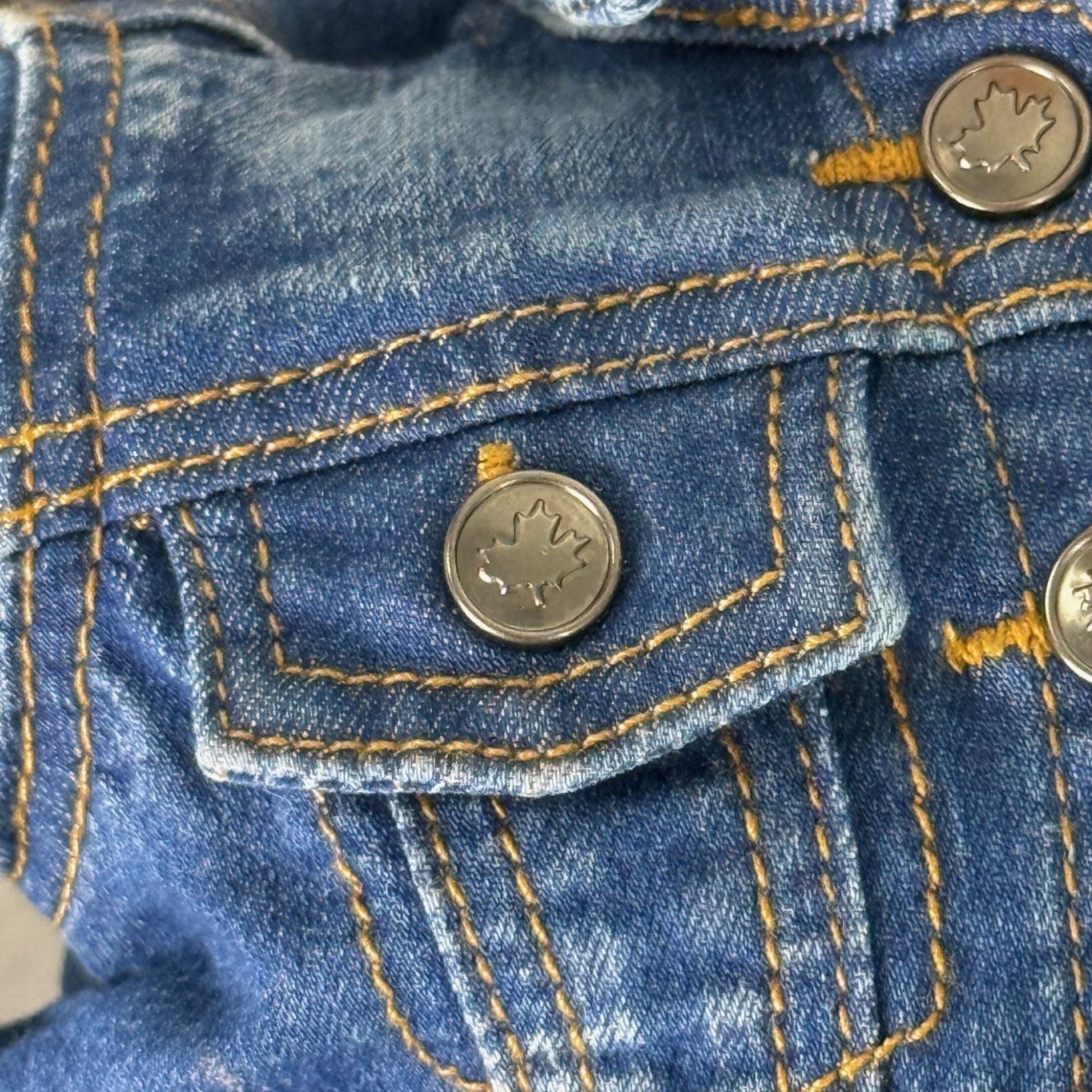 Close-up of a blue denim jacket with button details for 18-inch dolls