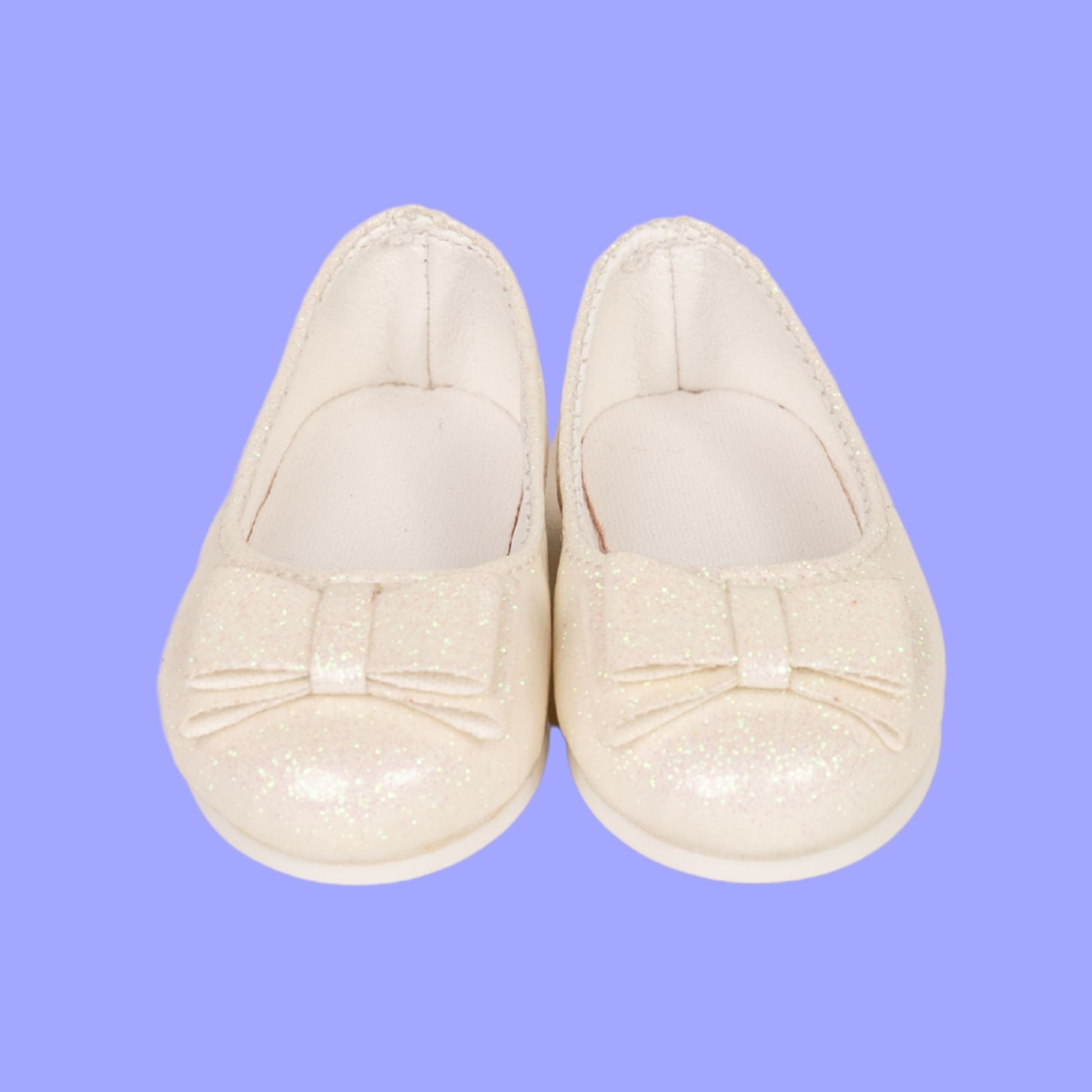 Pair of white 18-inch doll shimmer slip-on shoes.