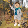 Maplelea boy doll wearing grey camping hoodie with matching teal graphic t-shirt, shorts and runners