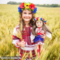 girl holding 18-inch doll wearing Ukrainian dance outfits