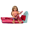 18-inch doll beside bed with harmony bedding on top