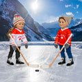 Two dolls playing hockey wearing Canadian hockey jerseys, with hockey sticks and a puck