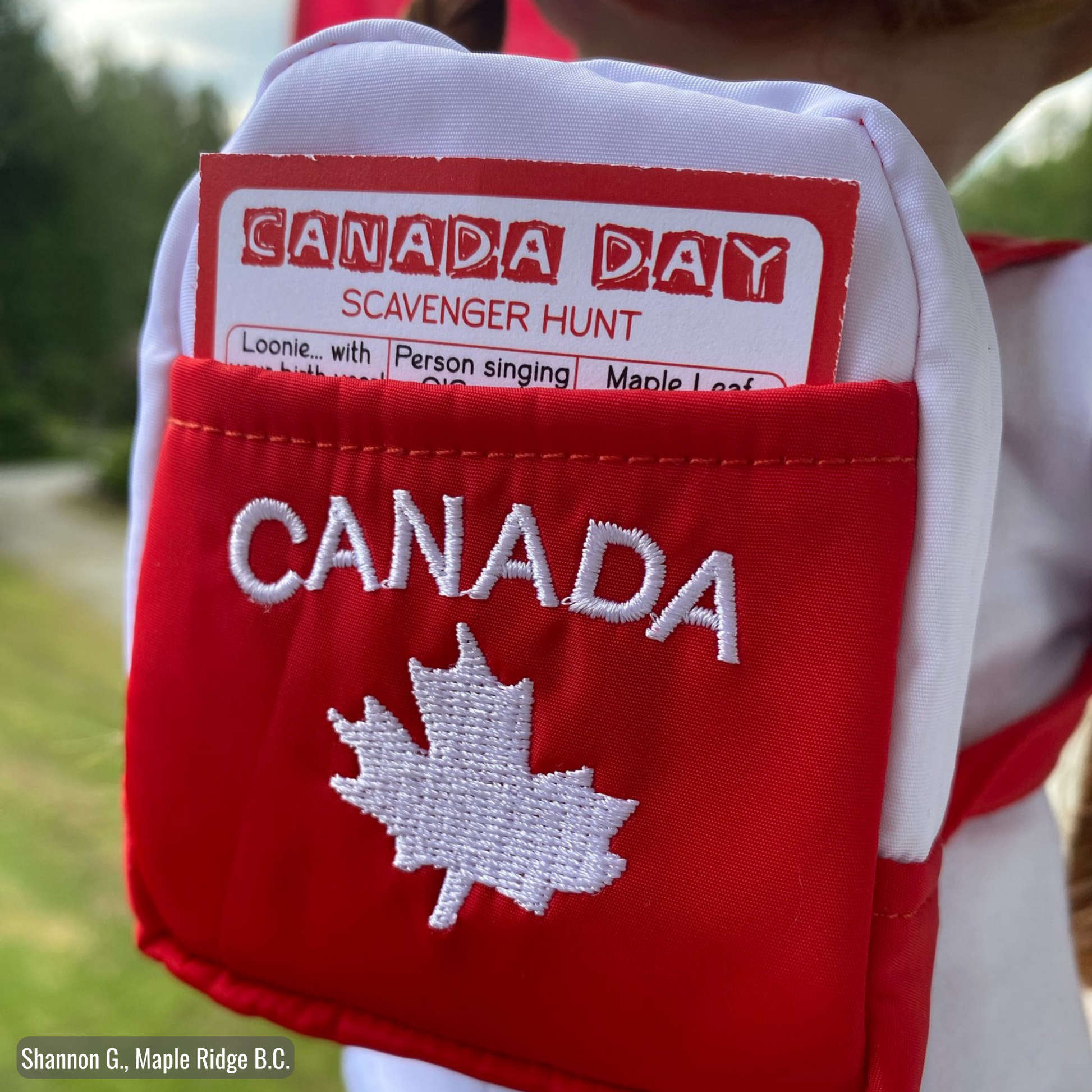 18-inch dolls wearing canadian themed red shorts, bucket hat, shirt with true north strong and free emblem, and backpack with embroidered mapleleaf, inside backpack pocket is a scavenger hunt card.