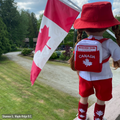 18-inch doll wearing canadian themed red shorts, bucket hat, shirt with true north strong and free emblem, and backpack with embroidered maple leaf.