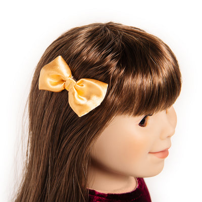 18-inch doll with bow on a clip in her brown hair