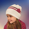 young girl wearing white hat with pink stripes matching doll's hat