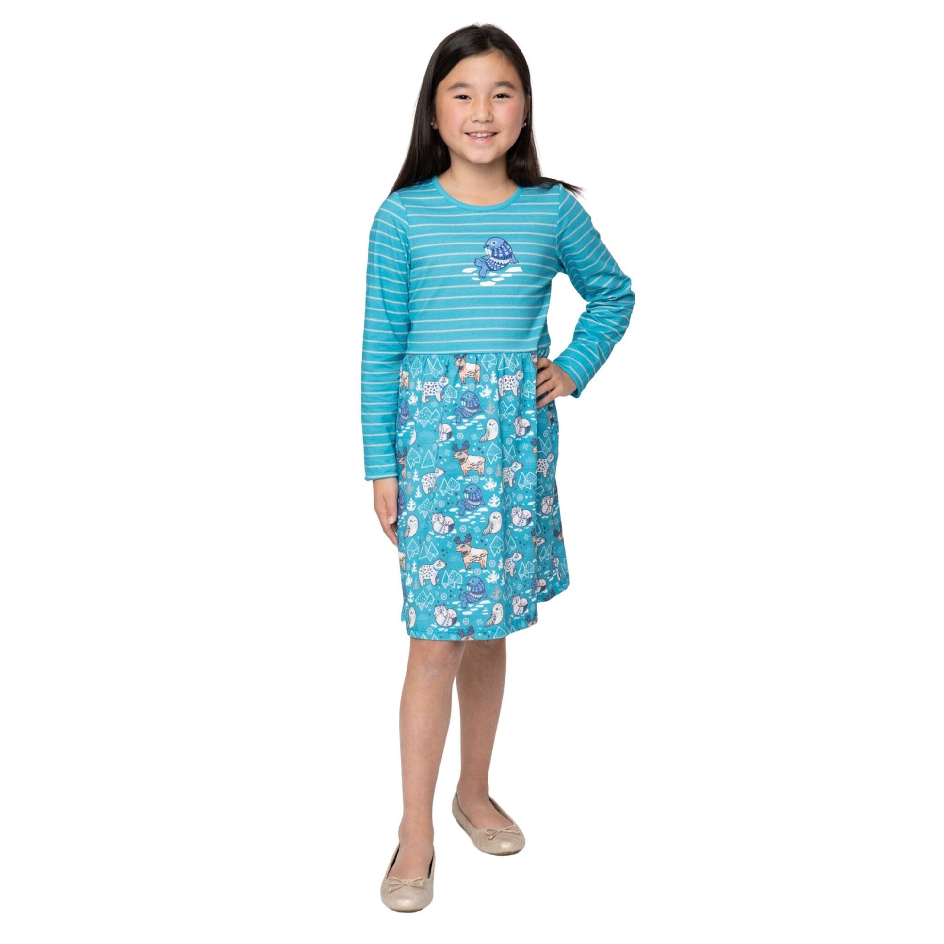 Girl wearing her blue dress with an arctic animals print.