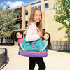 Girl with Maplelea Doll Tote in teal, pink and purple carries two dolls.