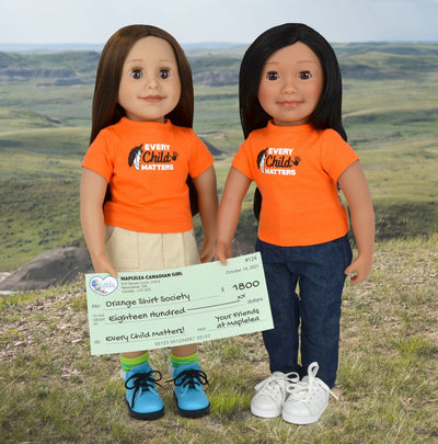 18" doll Taryn and Saila wearing orange every child matters graphic t-shirt presenting donation cheque for Orange Shirt Society