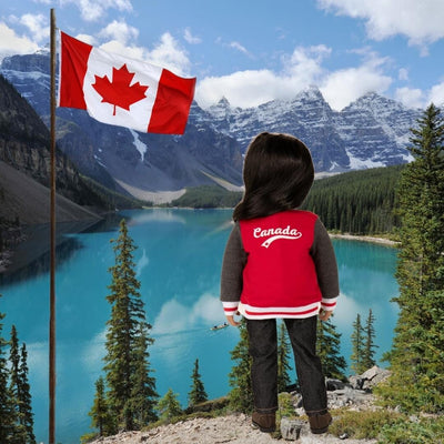the back of an 18-inch doll wearing a red Canada jacket as she looks over the Rocky Mountains