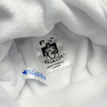 Close-up of a white plush fabric interior showing two labels: a black printed sewn label reading 'KILUK LTD' and a blue embroidered Maplelea label.