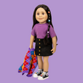 18-inch doll Alexi with a purple shirt and black skirt standing and arglye sweater standing on a street in Toronto.