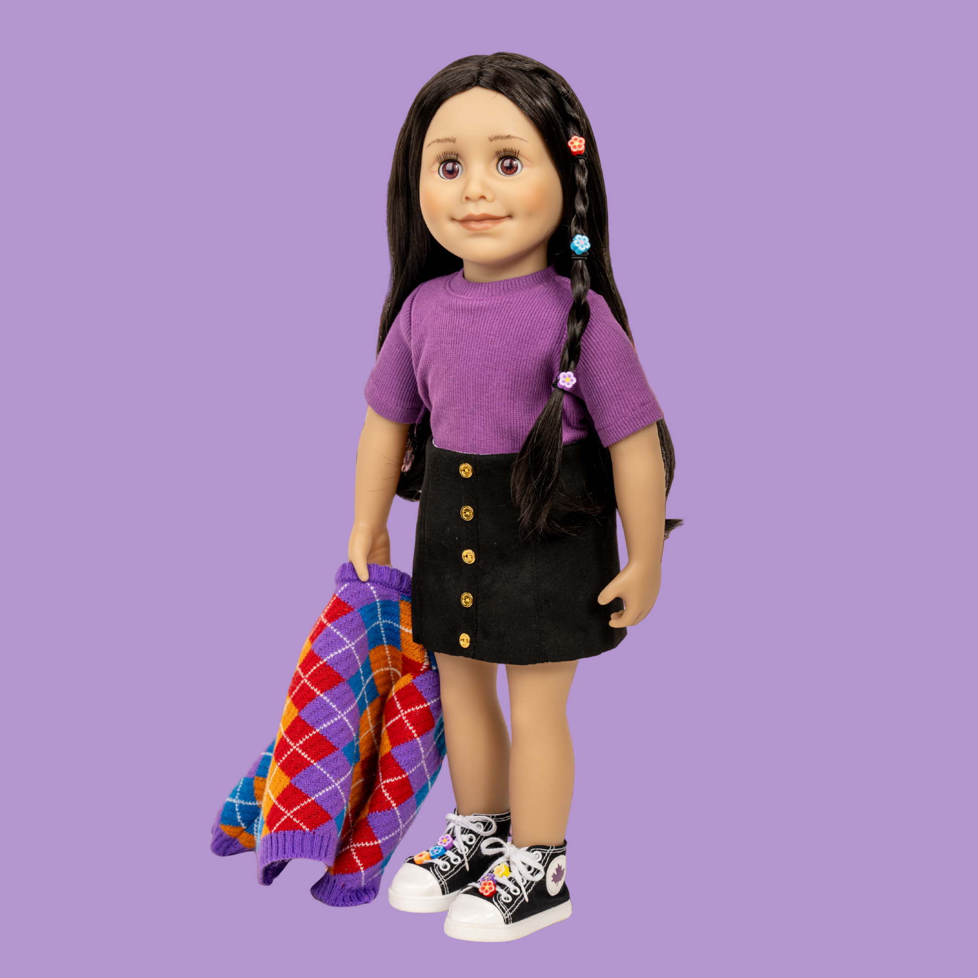 18-inch doll Alexi with a purple shirt and black skirt standing and arglye sweater standing on a street in Toronto.