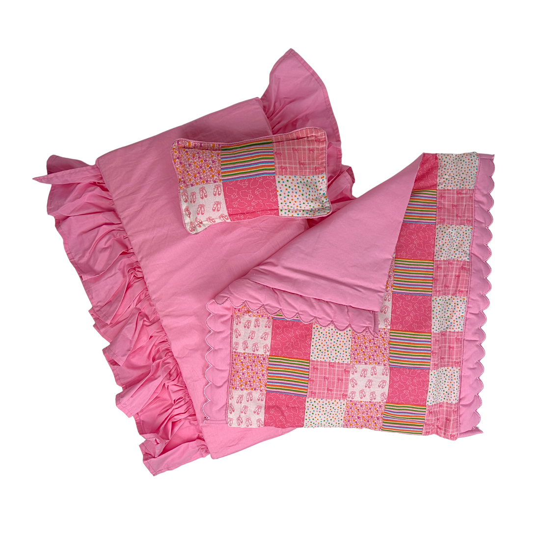 A white wooden doll bed with a pink patchwork quilt, matching pink pillow, and a ruffled pink bed skirt for Maplea Canadian dolls and other 18-inch dolls.