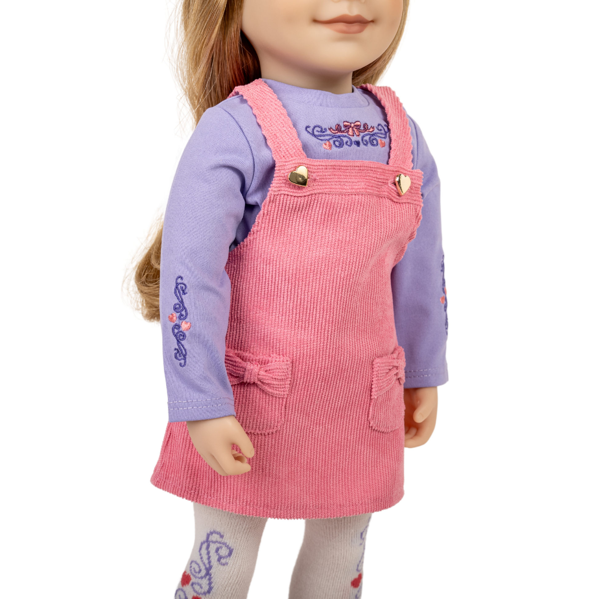 18-inch doll wearing a pink corduroy dress over a purple shirt.
