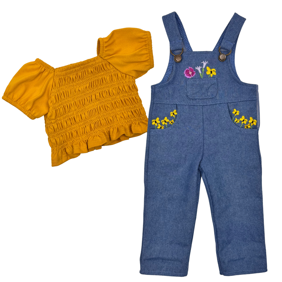 18-inch doll wearing a yellow shirt and blue jean overalls with floral embroidery. Flowers of Salt spring island.