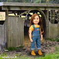 Doll in overalls in front of a barn with artistic embellishments on Salt Spring Island, BC