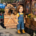 Charlsea doll wearing embroidered overalls in front of carved door at the Tree House Cafe in Salt Spring Island BC
