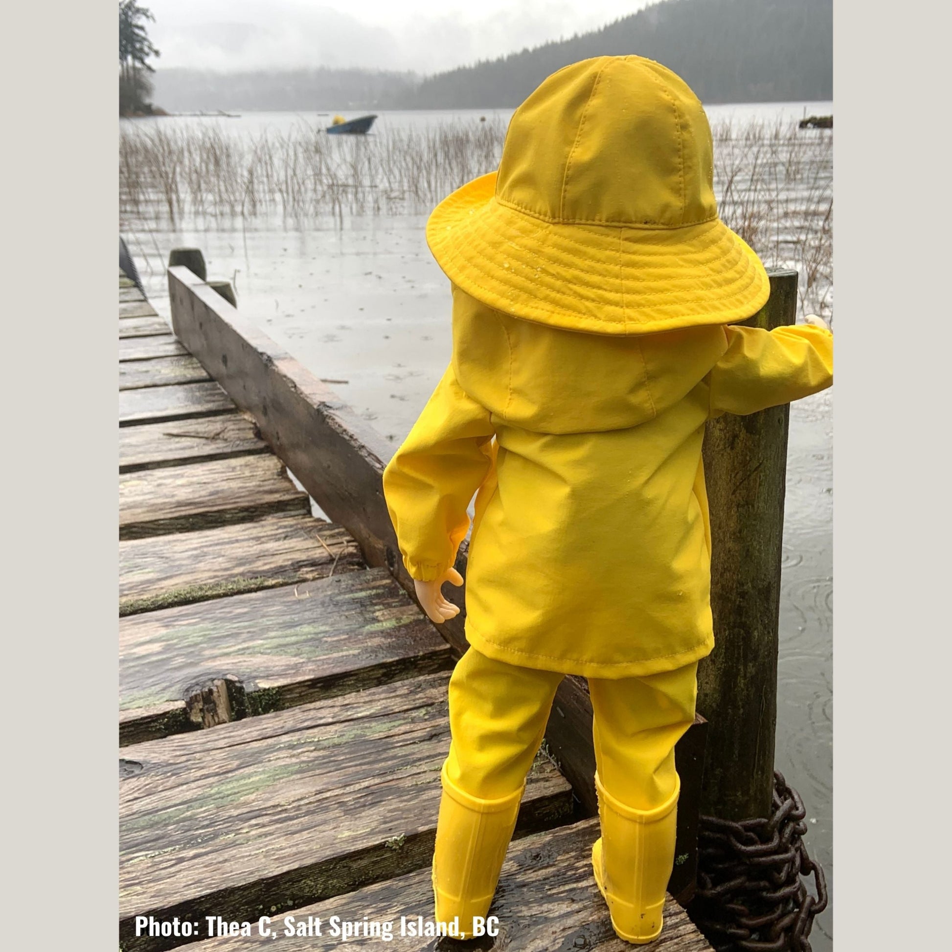 doll wearing a yellow sou'wester hat raincoat and boots standing on a wharf on Salt Spring Island British Columbia Canada