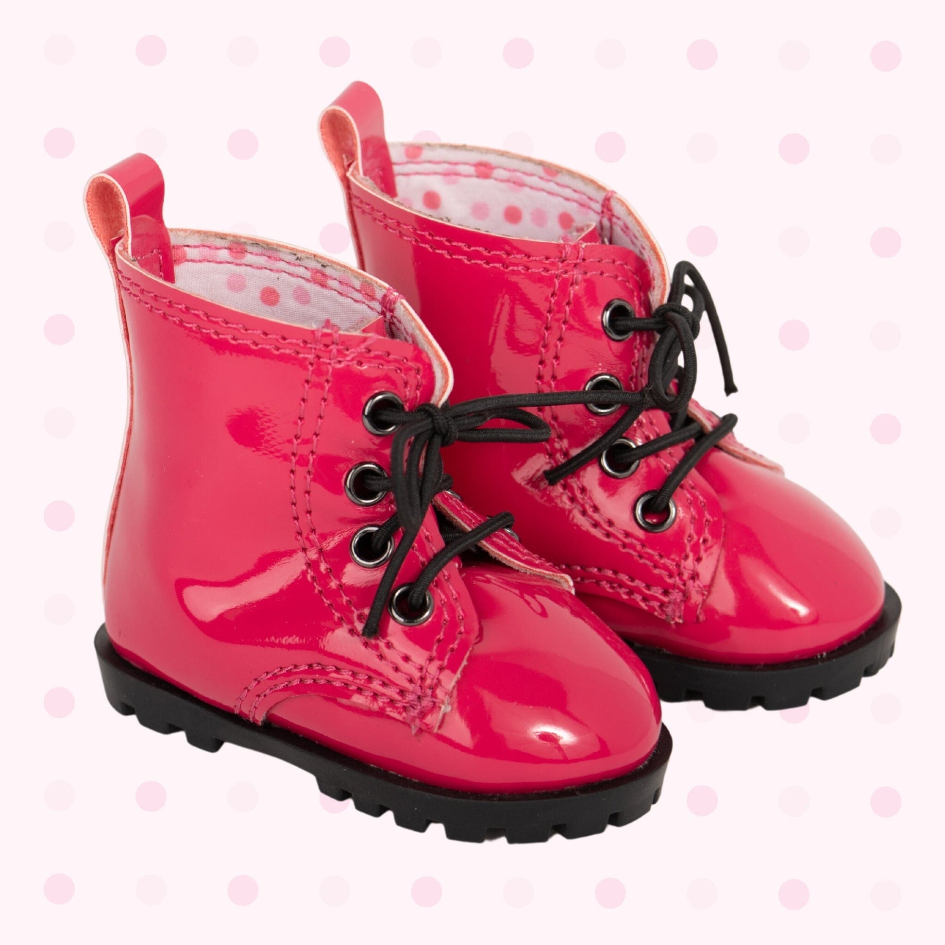 Cute bright pink patent lace-up boots with black soles and laces have polka dot lining