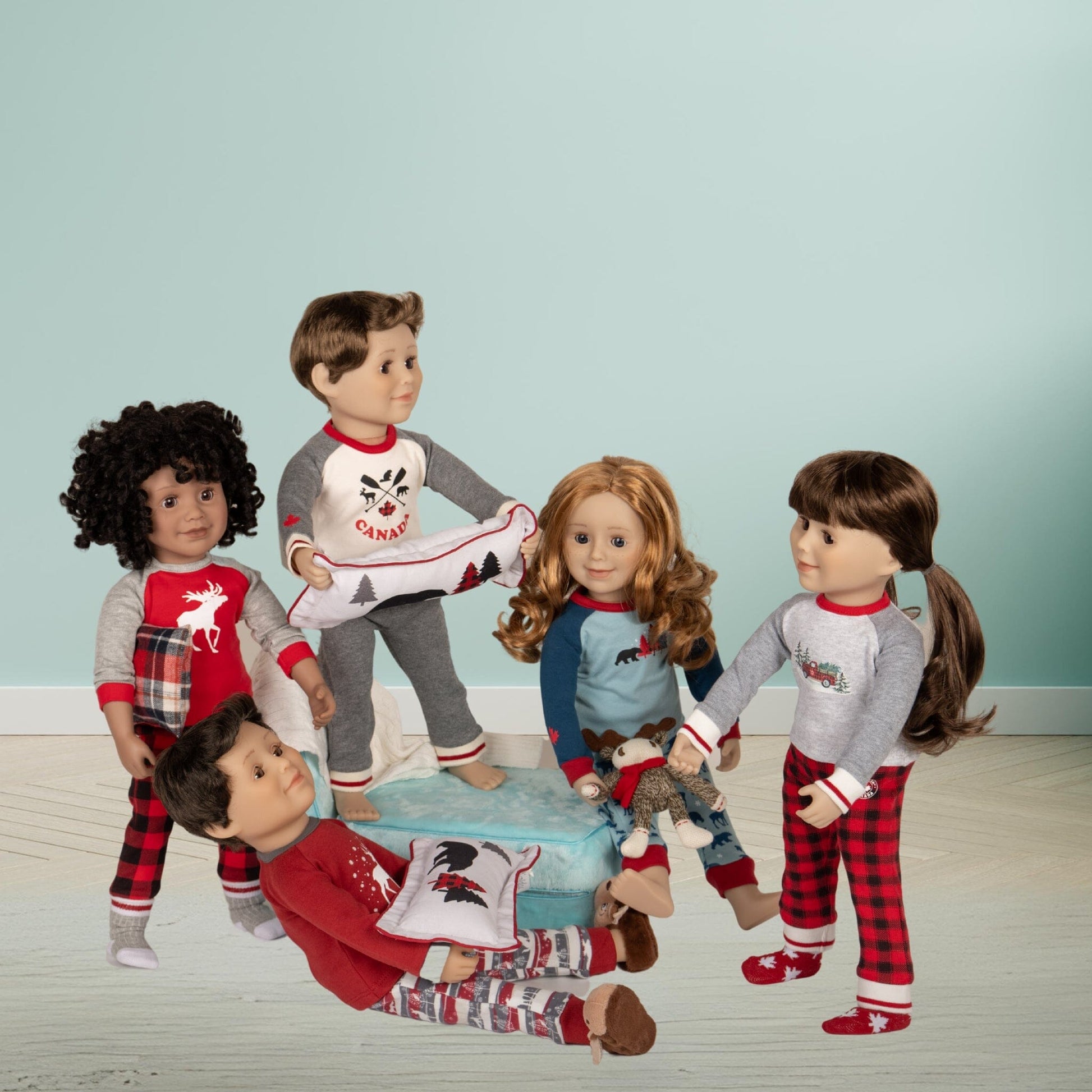 Maplelea dolls with pajamas on lounge chair with pillows blankets