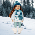 Doll wearing a winter outfit with a snowman sweater, blue hat, and scarf, with winter boots and sparkly leggings.