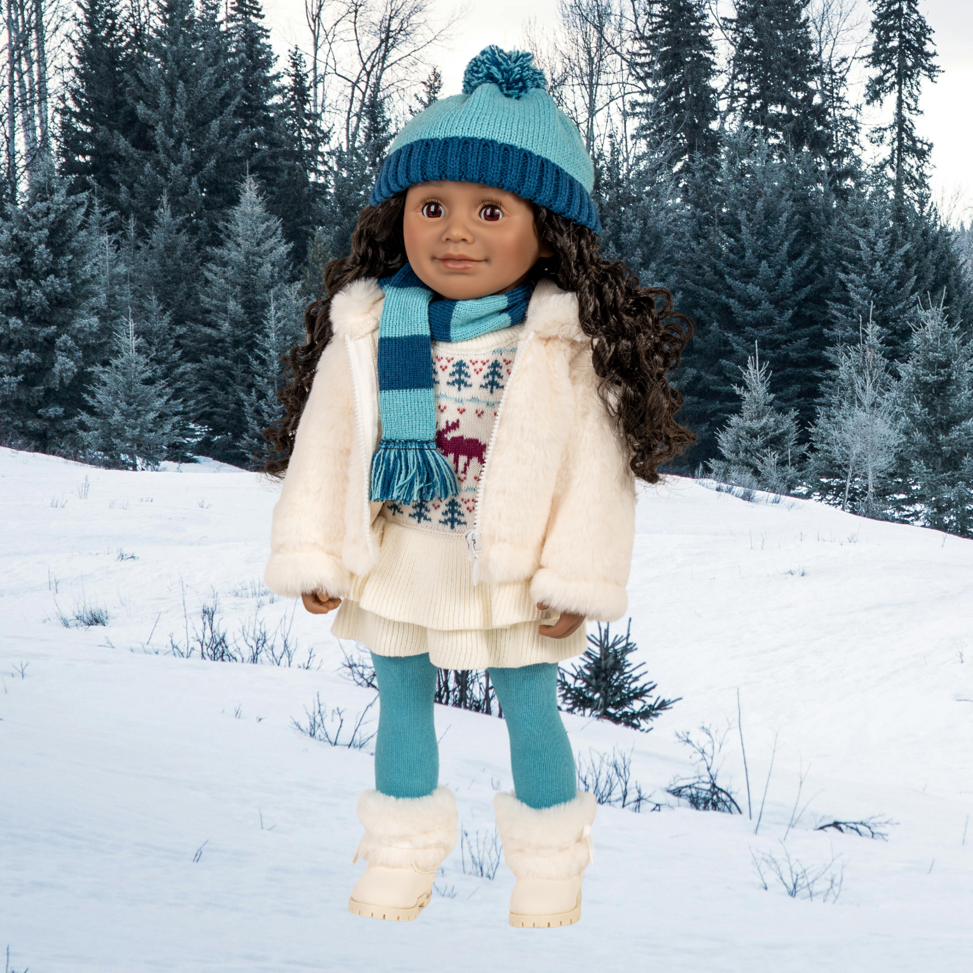 18-inch doll  in winter clothing and hat with scarf standing in a snowy landscape with trees.