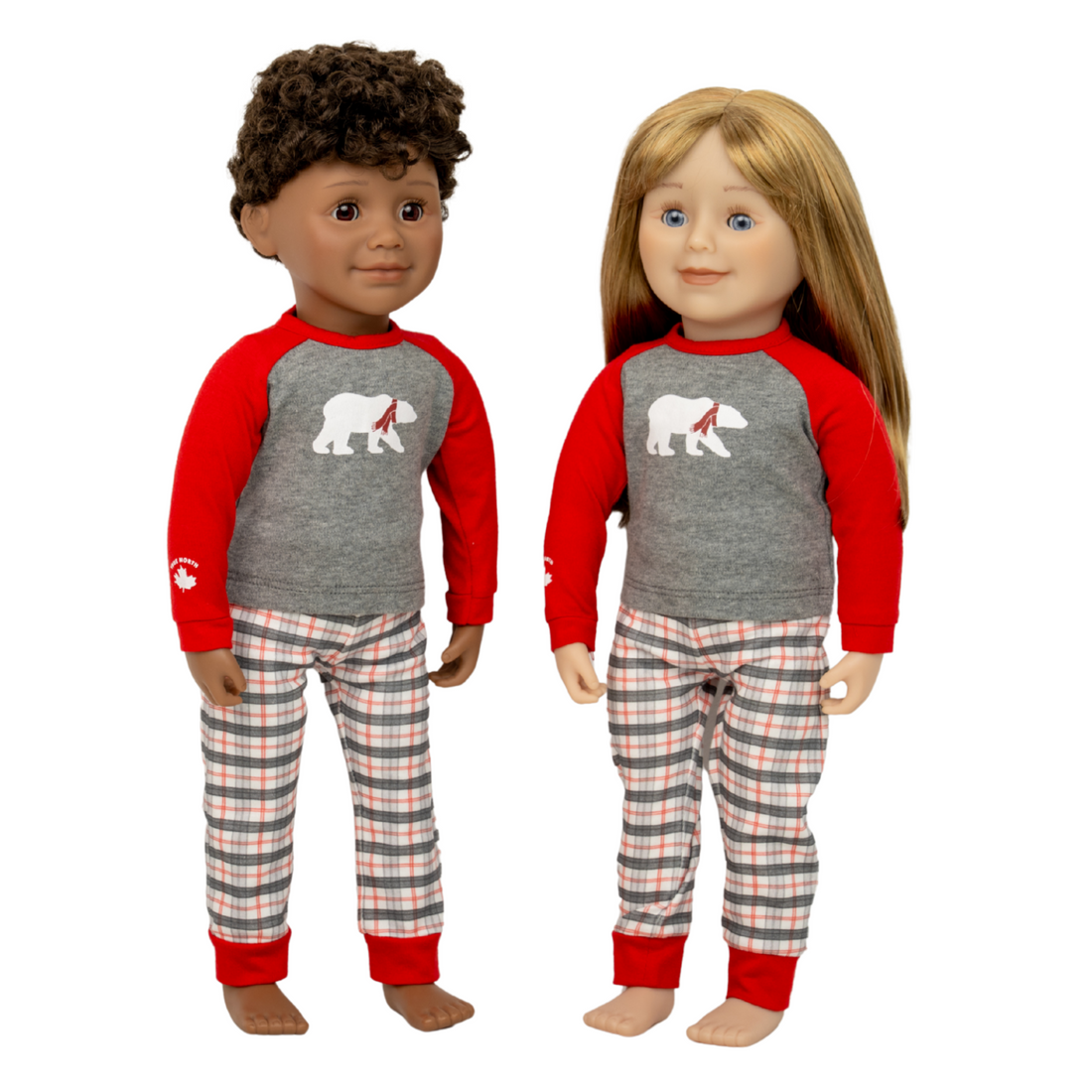 Two dolls wearing matching red and grey plaid polar bear pajamas.
