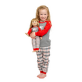 Child wearing red and gray polar bear pajamas holding a matching doll.