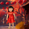 An Asian doll wearing a red dress celebrating Lunar New Year with red lanterns