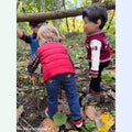 18-inch boy dolls playing in a forest wearing Fall Foliage outfit with puffer vest and Bear Track Canadian jacket and Grey Jay hiking boots
