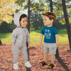 Maplelea boy dolls in grey camping attire with teal graphic t-shirt in forest