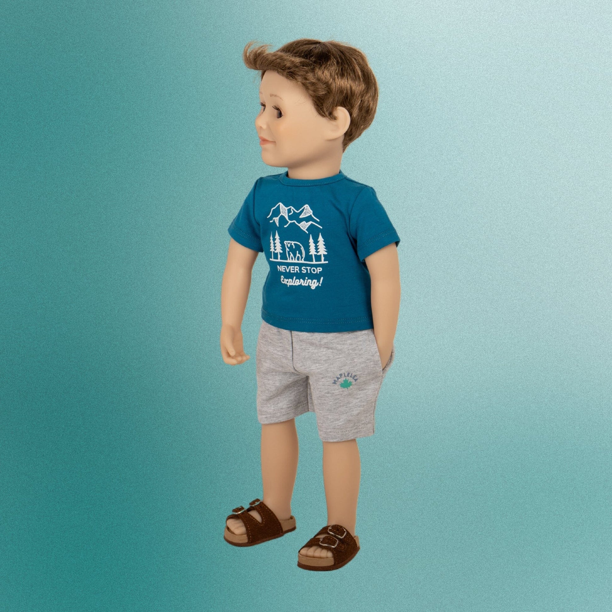 18" boy doll in a summer outfit with a graphic t-shirt shorts and brown buckle sandals 