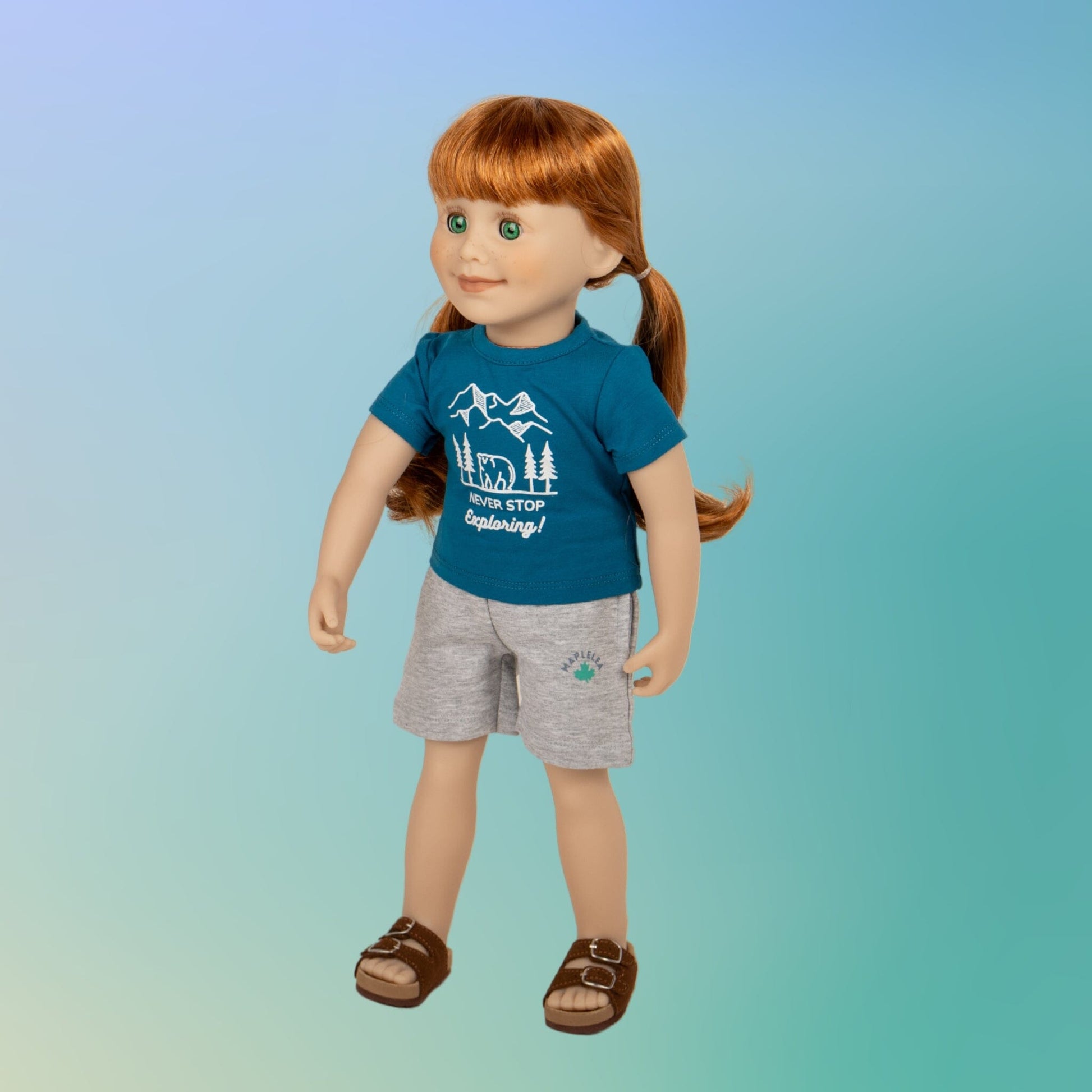 18" Jenna girl Maplelea doll wearing a graphic t-shirt shorts and brown buckle sandals 