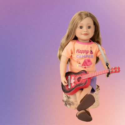 Leonie 18" doll wearing happy camper short summer pajamas with brown sandals and playing guitar