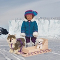 Quamutiik sled shown with Saila, an 18-inch doll and her plush Inuit dog and puppy in snowy weather.