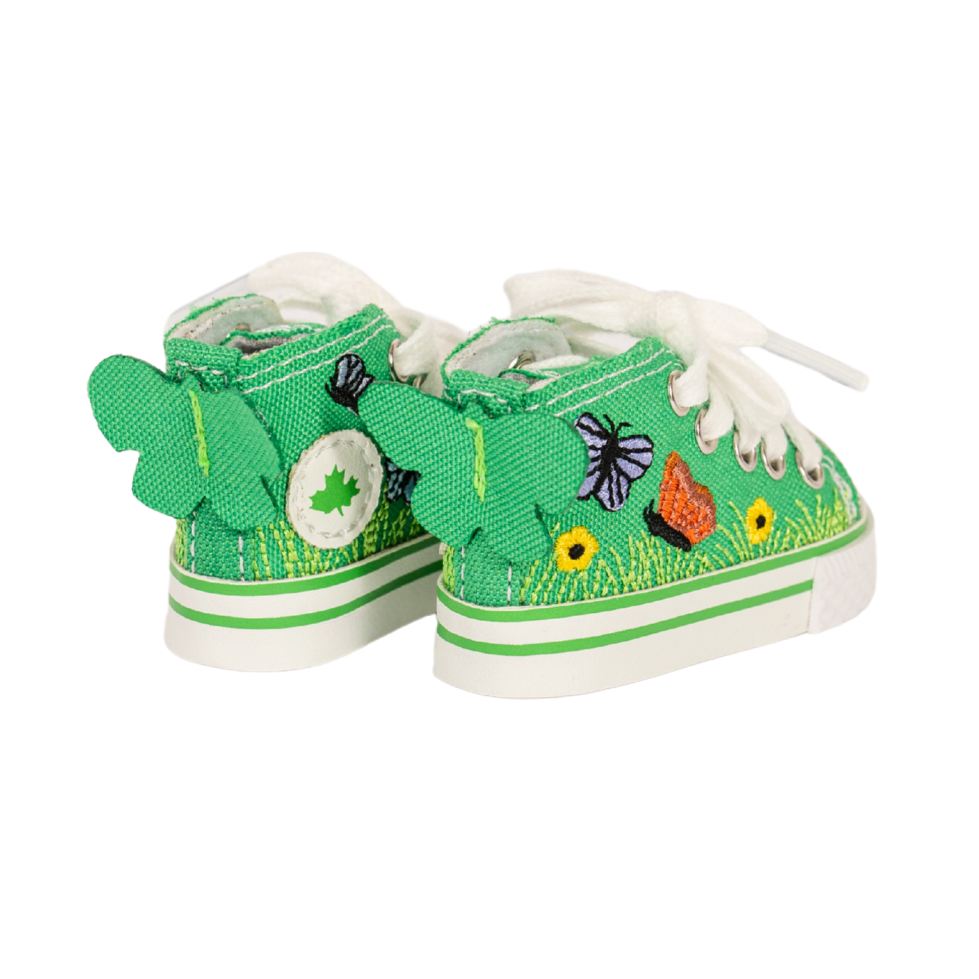 A pair of green canvas high-top sneakers with white laces, featuring embroidered spring-themed details including a butterfly, a maple leaf, a flower, and a butterfly on the side, set against a plain white background.