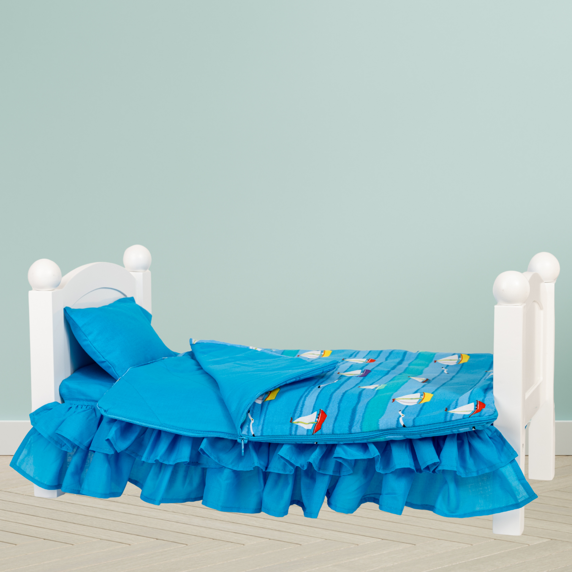 Blue bedspread with boat pattern on a white bed for 18-inch dolls.