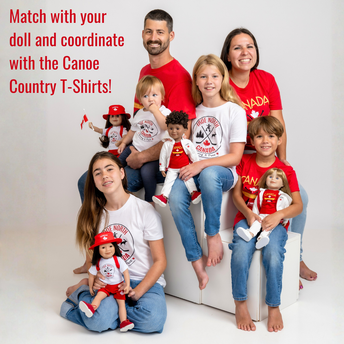 Toddler wearing a white “True North Canada” graphic T-shirt and blue jeans, standing against a light gray background. The shirt features a circular red-and-black design with crossed hockey sticks, a maple leaf, evergreen trees, a moose, and an Inukshuk, along with the words “True North,” “Canada,” and “Strong & Free.” The child is looking slightly to the side with a cheerful expression.