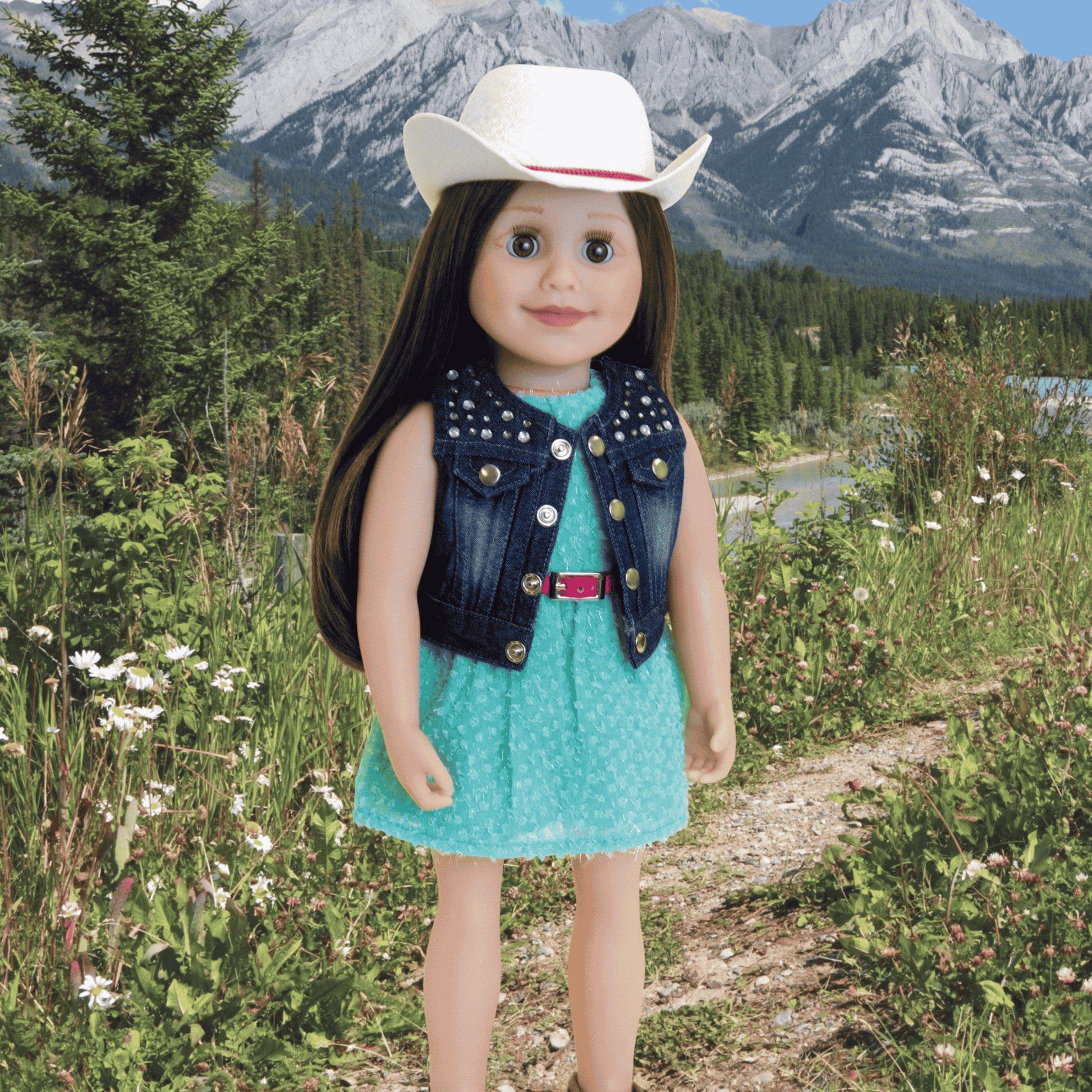 18-inch doll in a turquoise dress and white cowboy hat standing on a hiking trail.