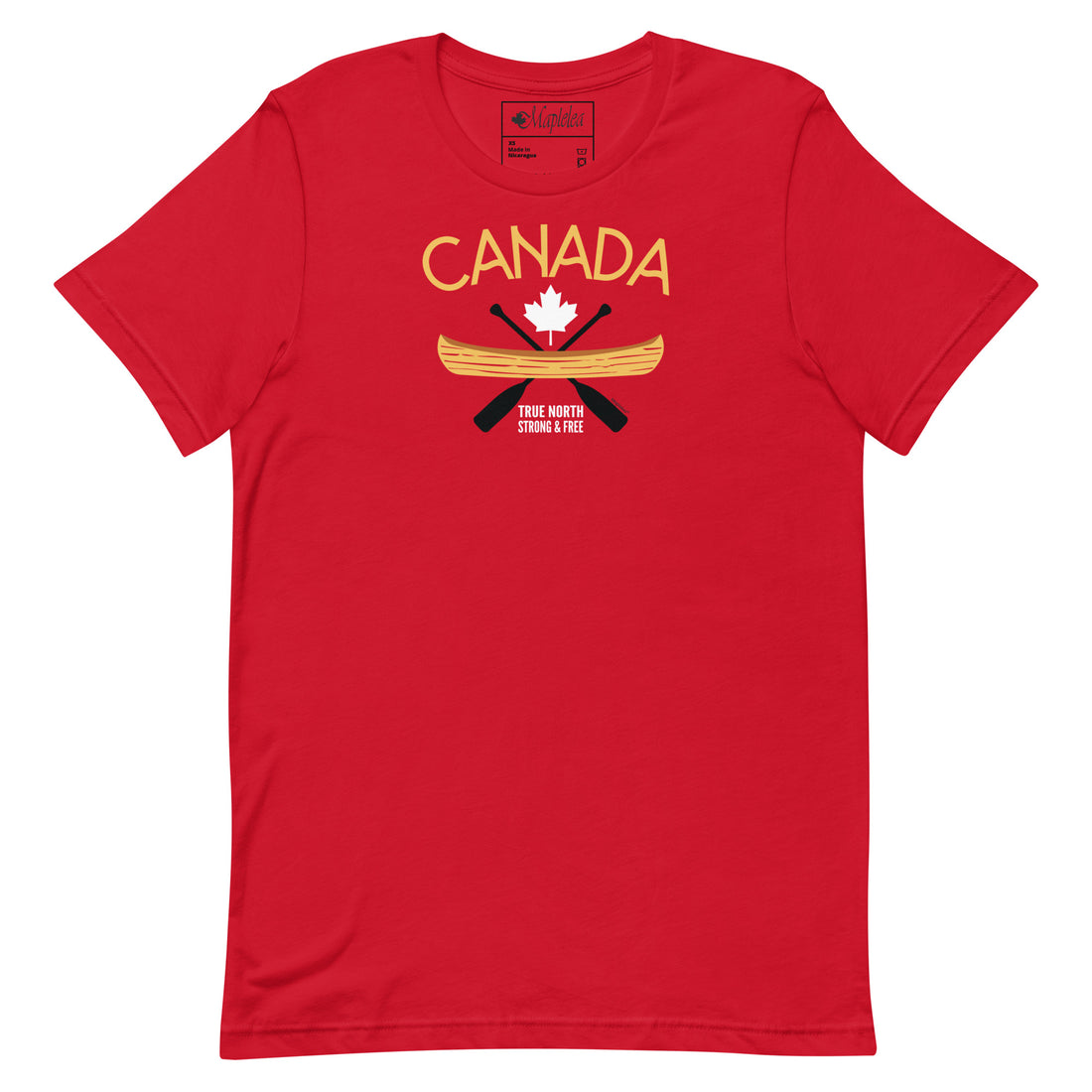 Two women stand outdoors smiling and talking while wearing matching red Canada-themed T-shirts with a canoe and maple leaf graphic. Trees, grass, and a building are visible in the background on a sunny day.