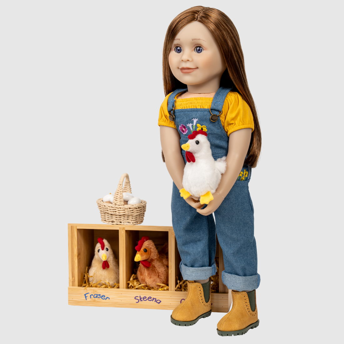 Doll in overalls holding a toy chicken with a wooden crate of chickens with a basket of eggs.