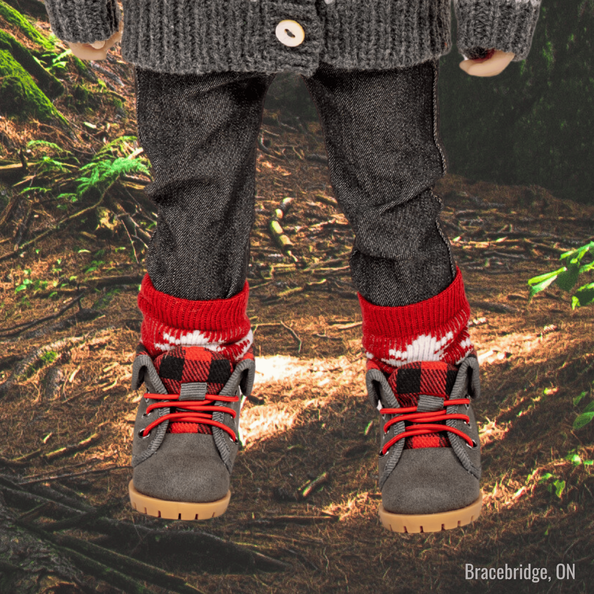 18-inch doll standing in Bracebridge forest wearing grey and plaid hiking boots with red maple leaf socks.