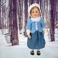 léonie wearing traditional Canadian pioneer outfit with skirt blouse scarf apron bonnet tights and shoes.